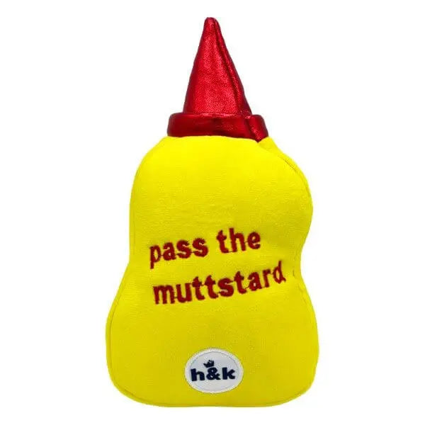 Żółta pluszowa zabawka dla psa w kształcie musztardy z napisem „pass the muttstard” i czerwoną nakrętką, od Huxley & Kent.